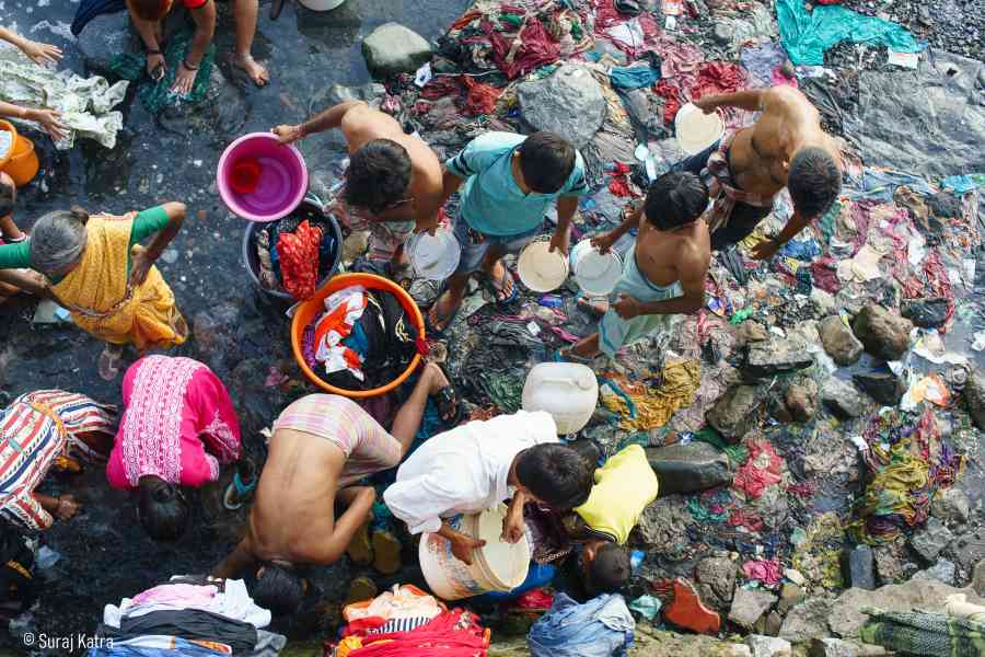 Residents using a leakge outlet to wash clothes (Image Source: Suraj Katra)