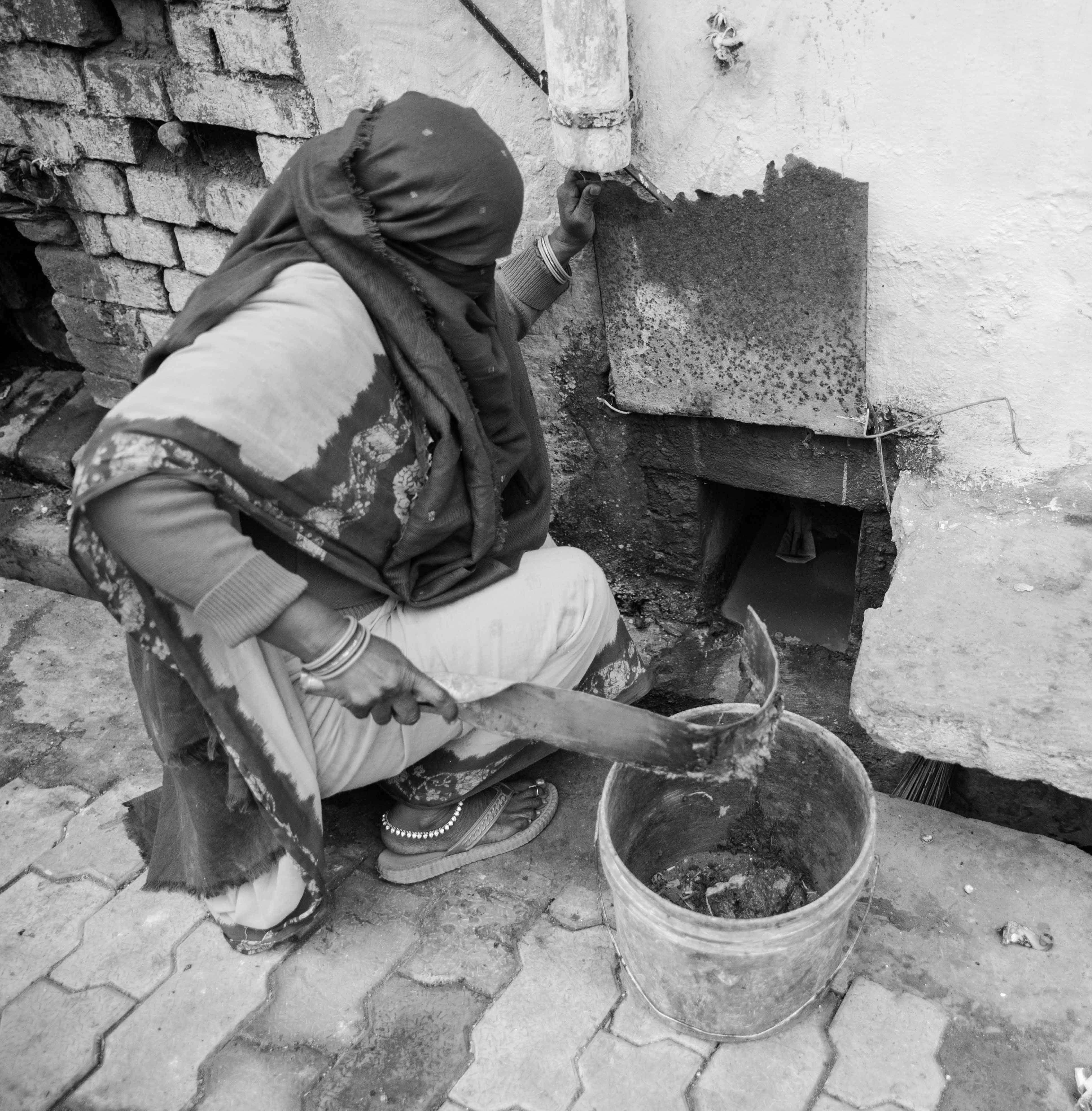 Vasumati cleans a household latrine.