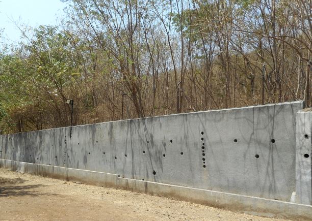 Walls with holes to direct rainwater flowing from the hills to the dug out canals.