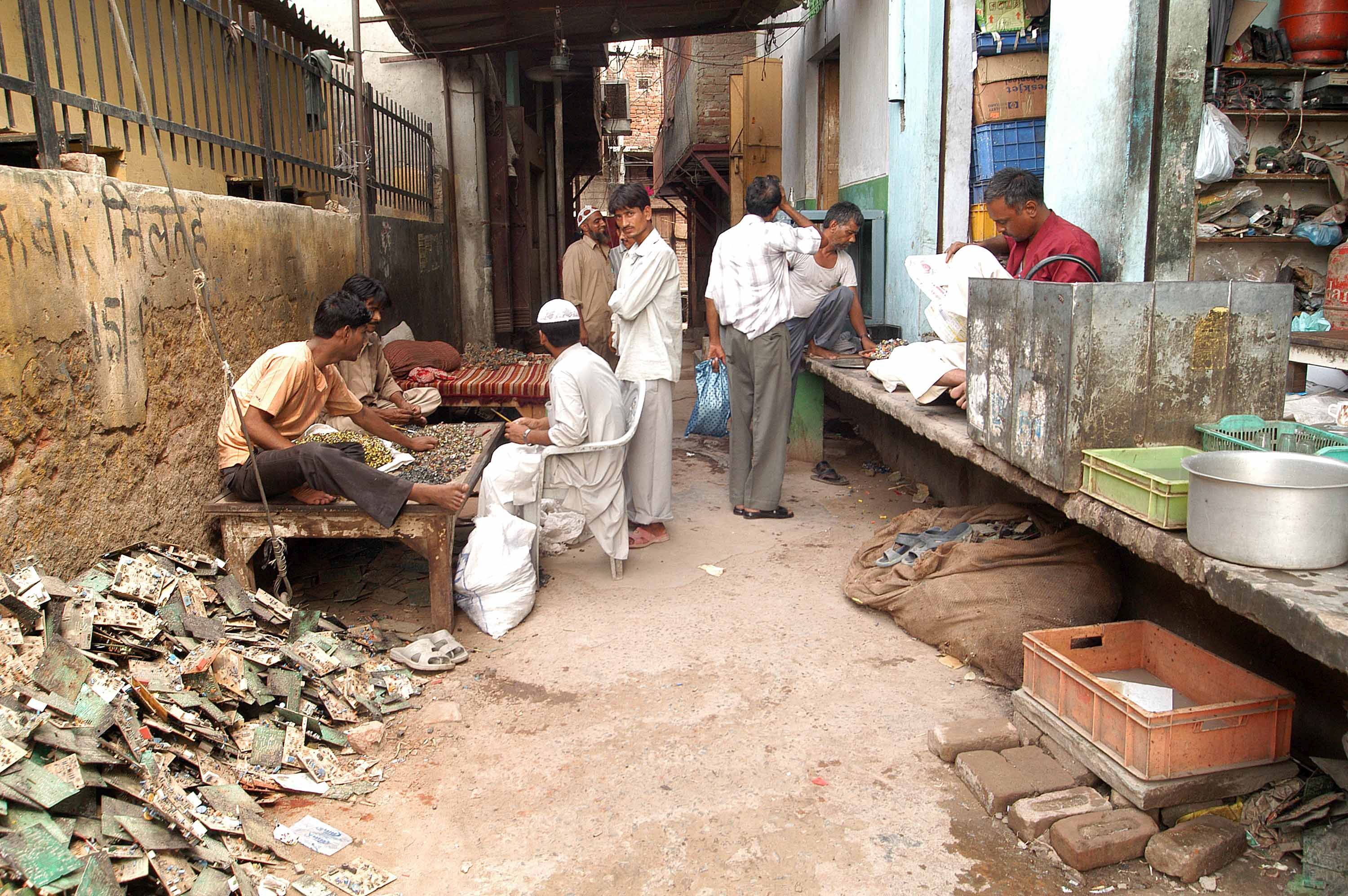 Recycling yard workers engrossed in their work in a narrow, open lane in Delhi. (Image: Greenpeace. (Flickr Commons; CC BY-ND 2.0)