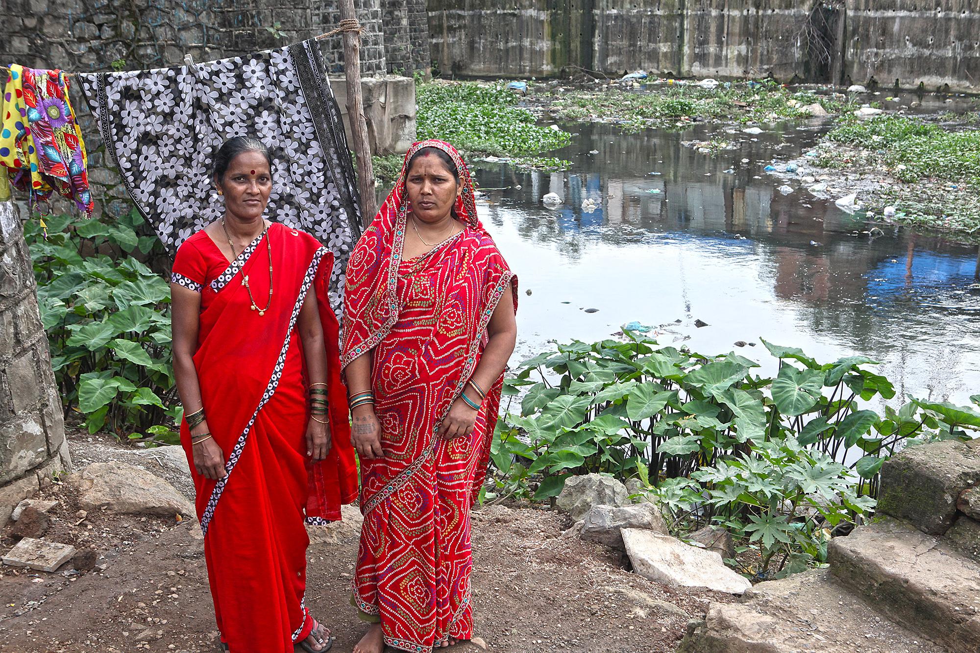 Kaleshwari Yadav (right) poses outside her home along the river at Morarji Nagar.