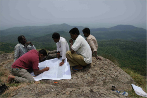 Soligas sitting on a mountaintop and mapping their land