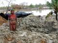 A woman searching for her utensils in debris of her house which collapsed after Cyclone Aila (Image: Anil Gulati, Wikimedia Commons)