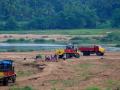 Trucks looting sand from a river (Image: Arayilpdas, Wikimedia Commons)