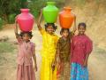 Girls carrying water (Source: Wikimedia Commons)