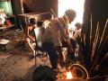 Boys sort discarded computer parts as sparks fly from a grinding machine. (Image: Greenpeace, Flickr Commons; CC BY-ND 2.0)