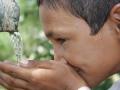 A school boy from Tilonia in semi-arid region of Rajasthan drinks from a tap from a rainwater harvesting tank that provides clean drinking water. (Image: Barefoot photographers of Tilonia)