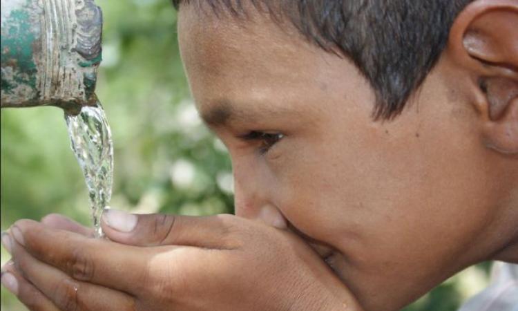 A school boy from Tilonia drinks from a tap from a rainwater harvesting tank (Image: Barefoot photographers of Tilonia)