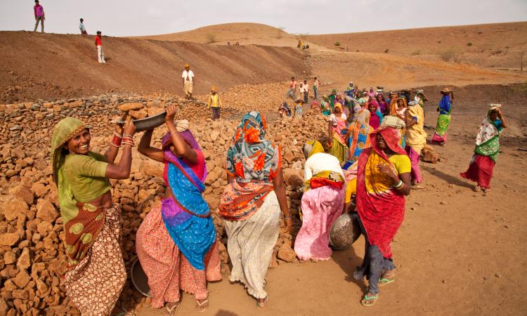 Women working on an NREGA site building a pond to assist in farming and water storage in Jhabua district (UN Women/Gaganjit Singh; CC BY-NC-ND 2.0 DEED)