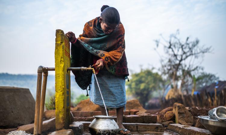 A Baiga woman reacts as she collects water from a standpost installed outside her house in Pondi village in Dindori, Madhya Pradesh (Image: WaterAid India)