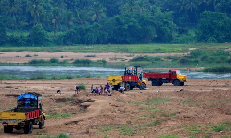 Trucks looting sand from a river (Image: Arayilpdas, Wikimedia Commons)