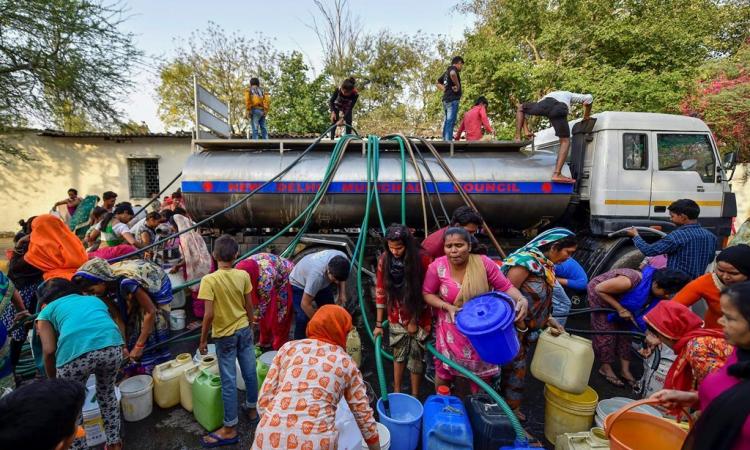 दिल्ली में पानी का संकट, टैंकर से पीने का पानी भरते लोग।