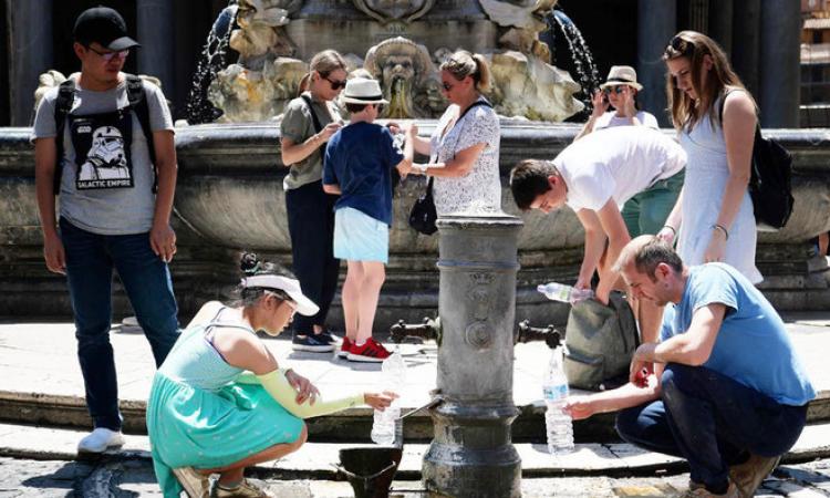 फ्रांस में गर्मी में तपती धूम में प्यास बुझाने के लिए पानी भरते लोग।