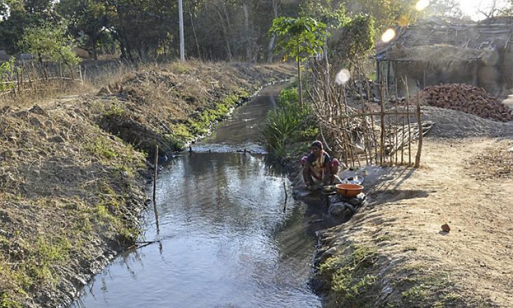 A villager washes utensils in the black water coming out of the coal mines at Kodkel in Raigarh district, Chattisgarh.