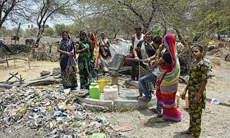 Women pump contaminated water from the hand pump at Bajankheda. (Source: India Water Portal)