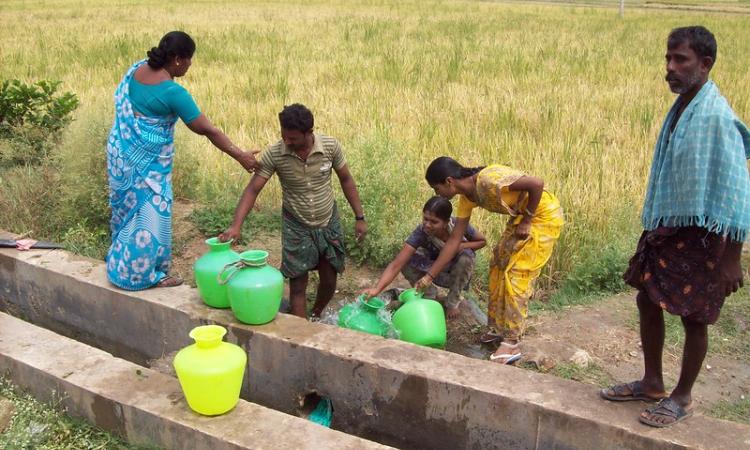 Villagers collecting borewell water from a private farmland (Source: IWP Flickr photos)