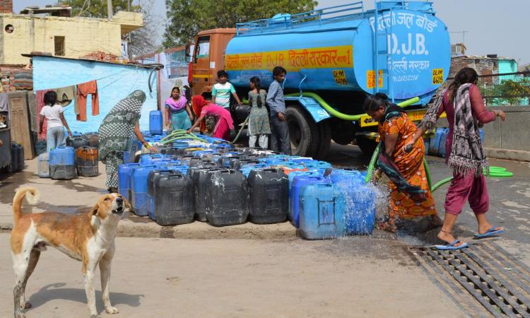 Residents of Kusumpur Pahari, a slum in south New Delhi, fill containers with water from a DJB tanker Source: Columbia Water Center/flickr