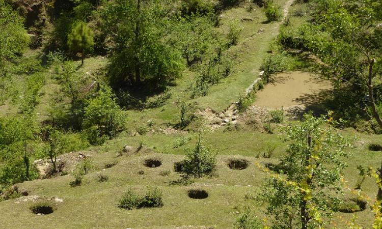 A traditional system practised in Uttarakhand, the circular pits on the slopes store rainwater and allow it to slowly percolate to the drain line, where water is stored in the pond.