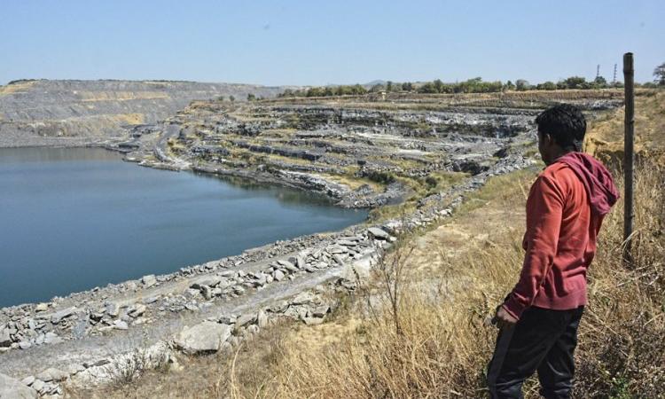 A villager looks at the changing landscape due to coal mines at Kosampalli village in Raigarh (Image source: IWP photo by Makarand Purohit)