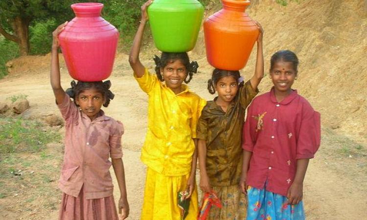 Girls carrying water (Source: Wikimedia Commons)