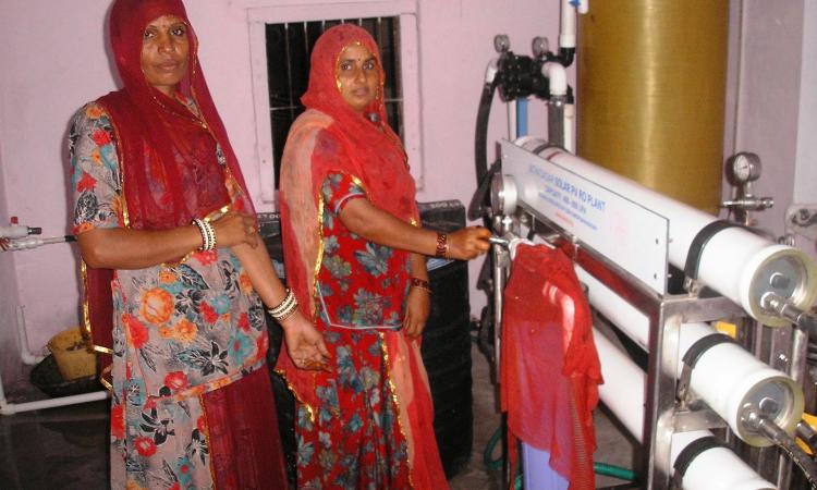 Villagers operate the solar-powered reverse osmosis desalination plant that provides safe drinking water to the community at Solawata.