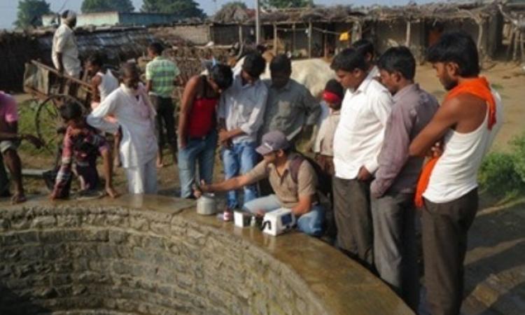 Manyali residents testing water from their well