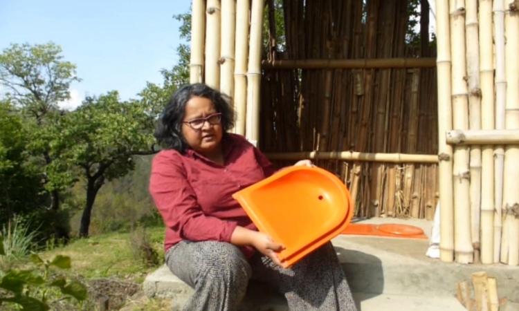 Chicu with a pan used in ecosan toilet. (Photo courtesy: Chicu Lokgariwar)