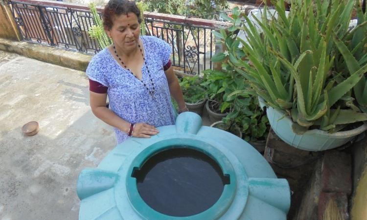 A resident in Delhi with her extracted groundwater (Source: IWP Flickr photos)