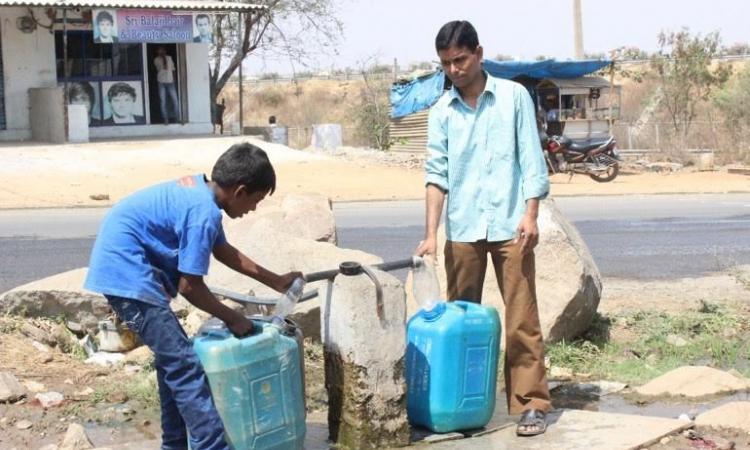 People take water from a common water point. (Source: SaciWATERs)
