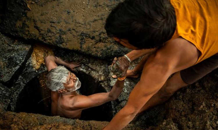 A latrine emptier is lifted out of a pit in Bangalore, India (Image: WaterAid/CS Sharada Prasad)